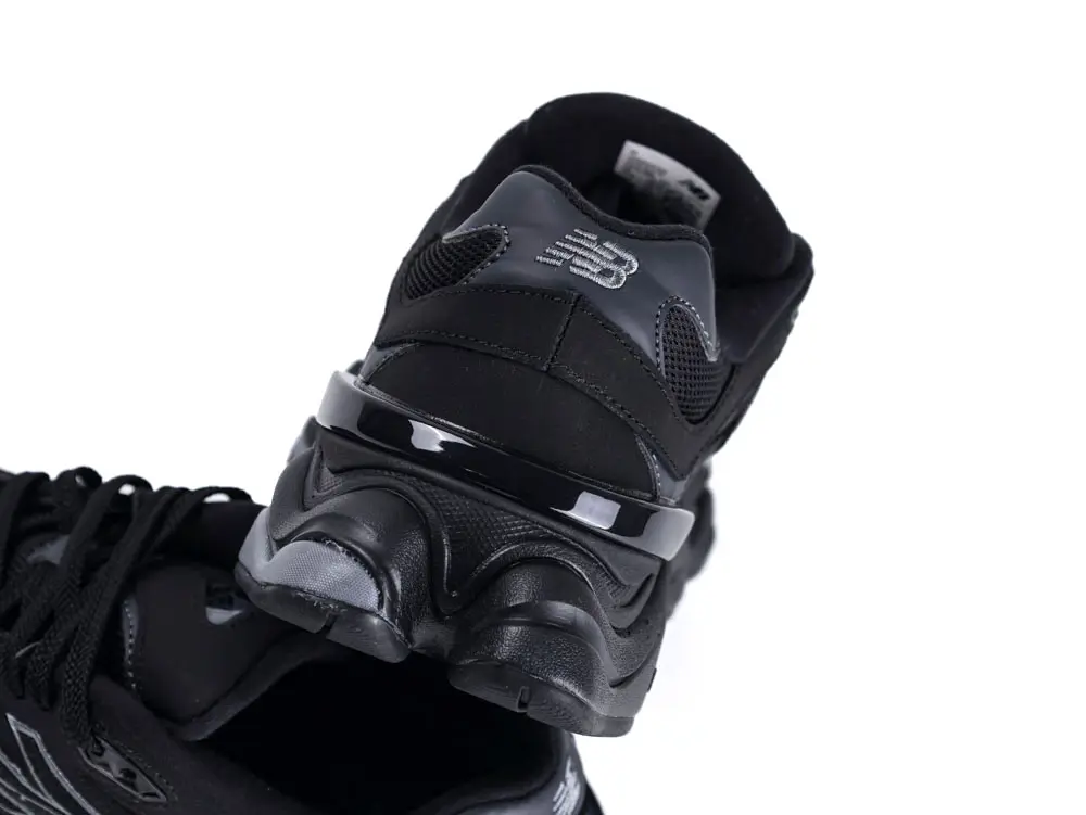 Close-up of black mesh and leather sneaker toe with textured detailing.