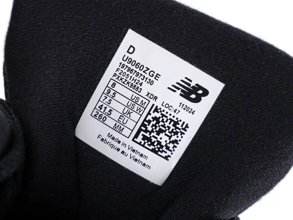Black fabric material tag with shoe size and manufacturing details printed on it.