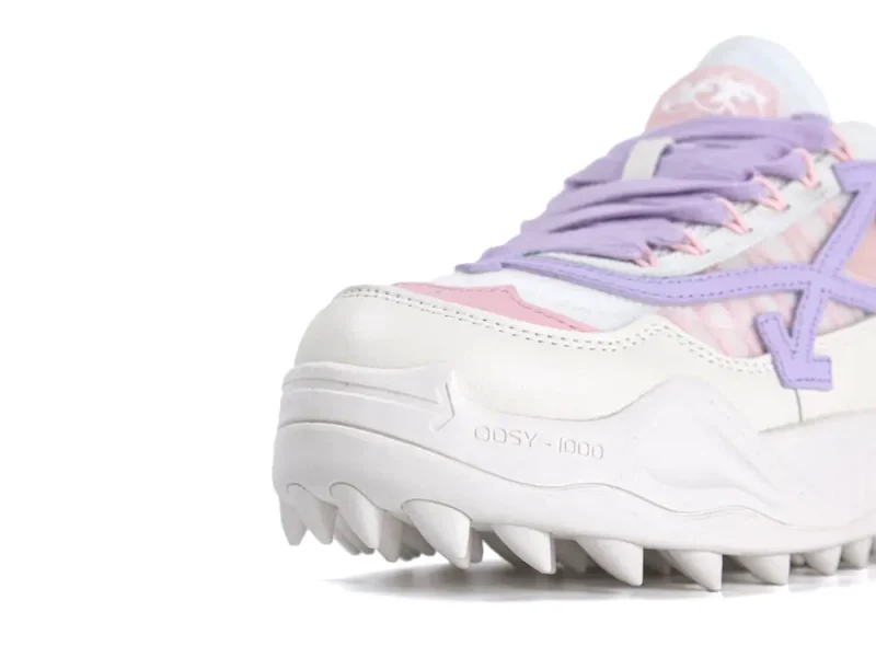 White and pink sneaker with purple details, featuring a rugged sole and leather material.