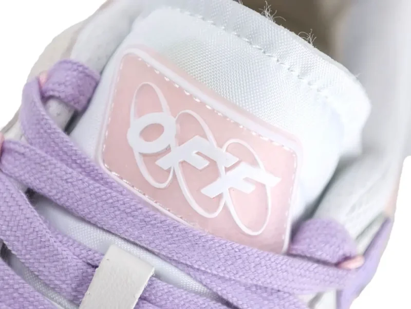 Close-up of a sneaker's lavender laces and pink tongue with logo detail.