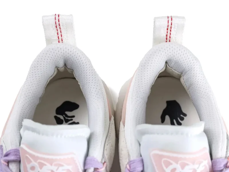White and pink sneakers with perforated fabric lining and purple laces, viewed from above.