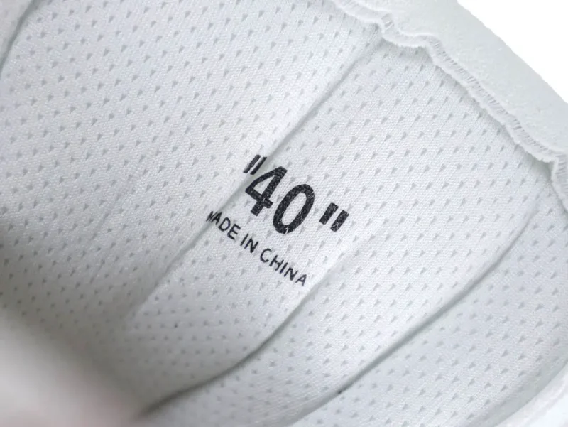 White fabric shoe interior with perforated texture and size label "40" printed inside.