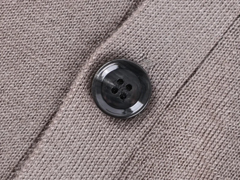 Button on textured knitted fabric garment.