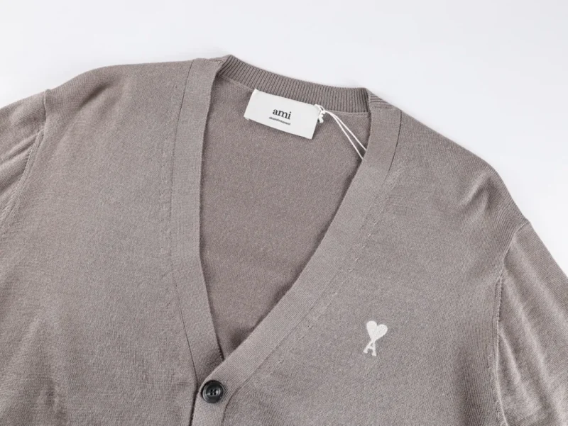 Knit cardigan with V-neck, button closure, and embroidered heart logo.
