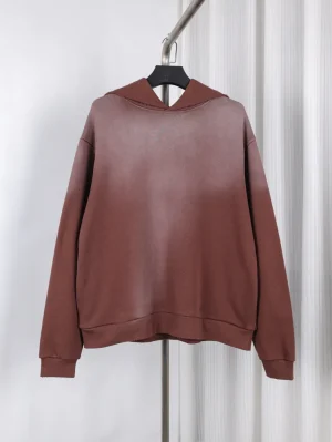 Brown cotton hoodie on hanger, featuring a simple design with ribbed cuffs.