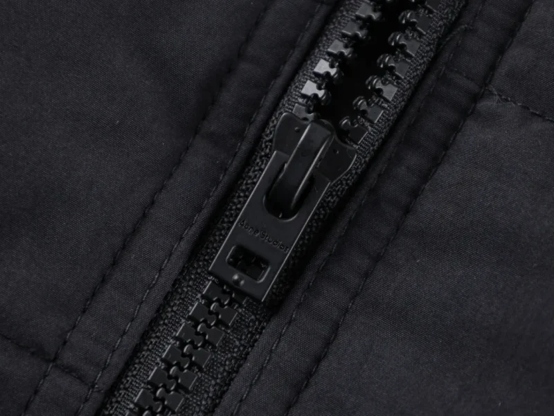Zipper on dark fabric material.