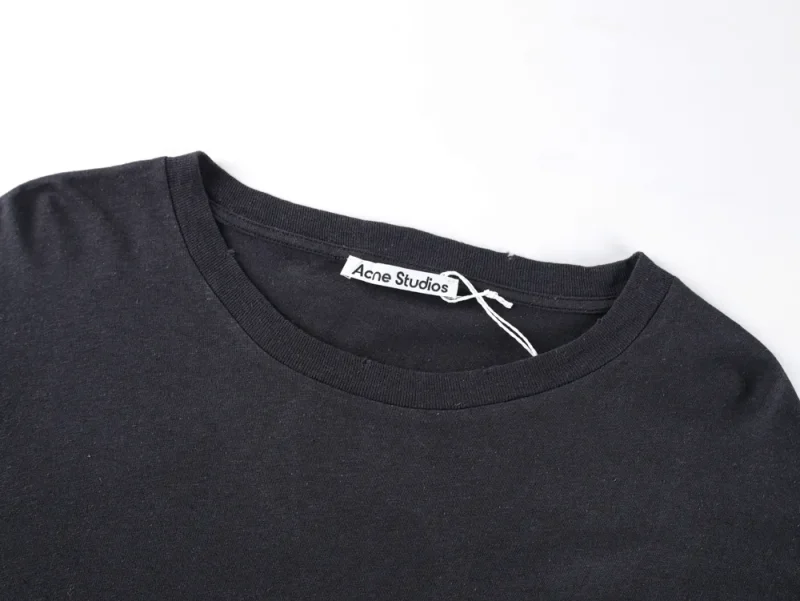 Black cotton t-shirt featuring a round neckline and a visible tag.