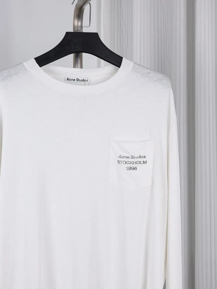 Semi close up long-sleeve shirt with chest pocket and printed text on hanger.