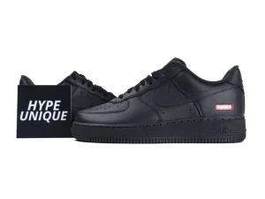 All-black leather sneakers with visible branding, rubber sole, and perforated toebox design.