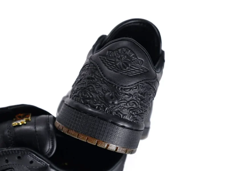 Black leather sneaker heel with intricate embossed design and textured sole detail.