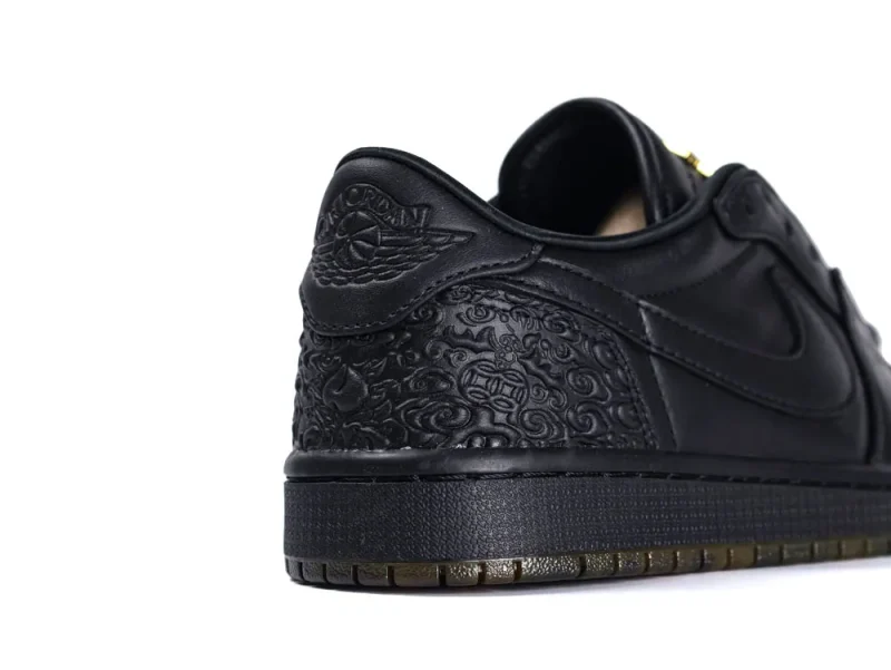Black leather sneaker heel with embossed pattern and textured rubber sole.
