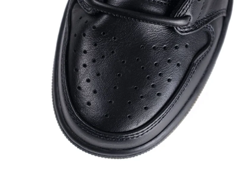Close-up of black leather shoe toe with perforated detailing.