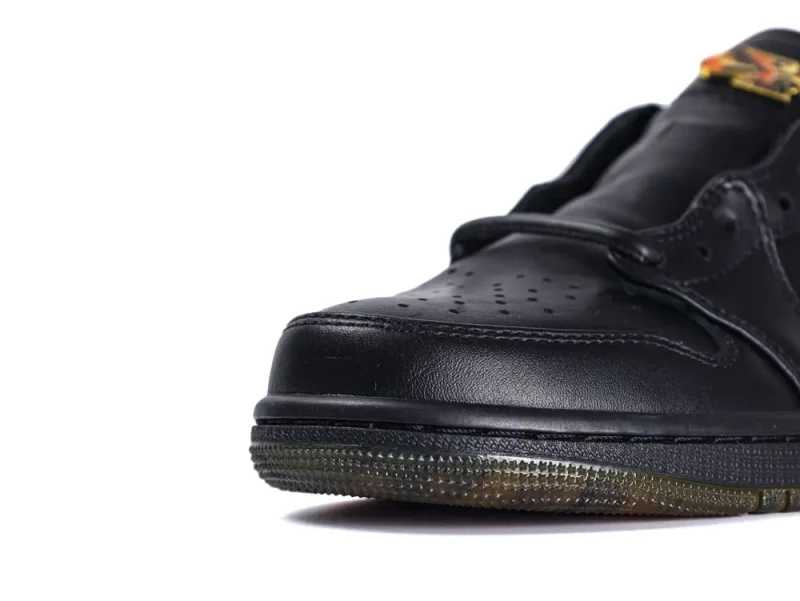Black leather sneaker with perforated toe box and a translucent rubber sole.