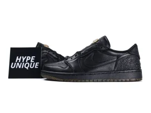 Black leather sneakers with intricate patterns, featuring a low-cut design and rubber soles.