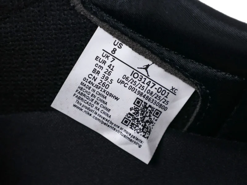 White fabric tag on black sneaker interior showing size and manufacturing details.