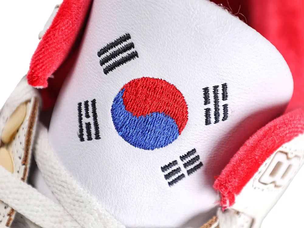 White leather shoe tongue with embroidered South Korean flag, red and blue details.