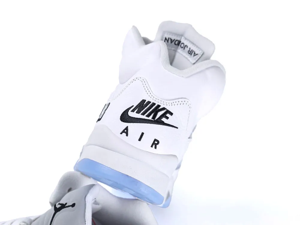 White leather sneaker with blue sole and black logo details on heel.
