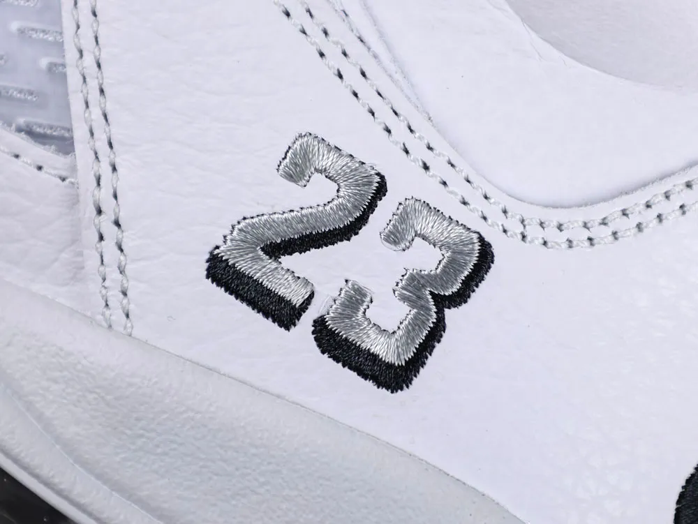 White leather shoe with stitched number "23" in silver and black thread.