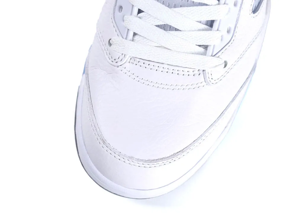 Close-up of a white leather sneaker toe with stitched details.