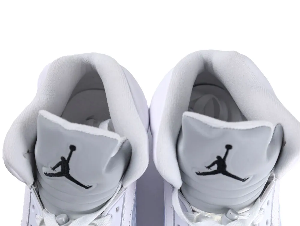 White leather sneaker tongues with black logo, featuring plush inner lining.