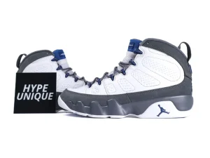 White and gray sneakers with blue accents, leather material, rubber sole visible.