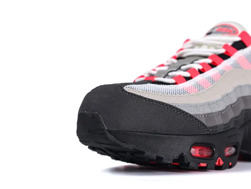 Close-up of sneaker's layered fabric, featuring gray, black, and red accents.