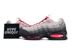 Gray and black sneakers with pink accents, mesh upper, and rubber sole.
