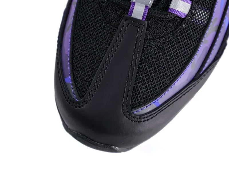 Close-up of a black and purple sneaker toe made of mesh and leather.
