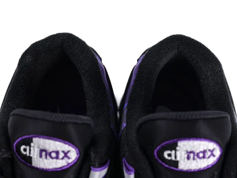 Close-up of black and purple shoe materials, focusing on the fabric tongue labels.
