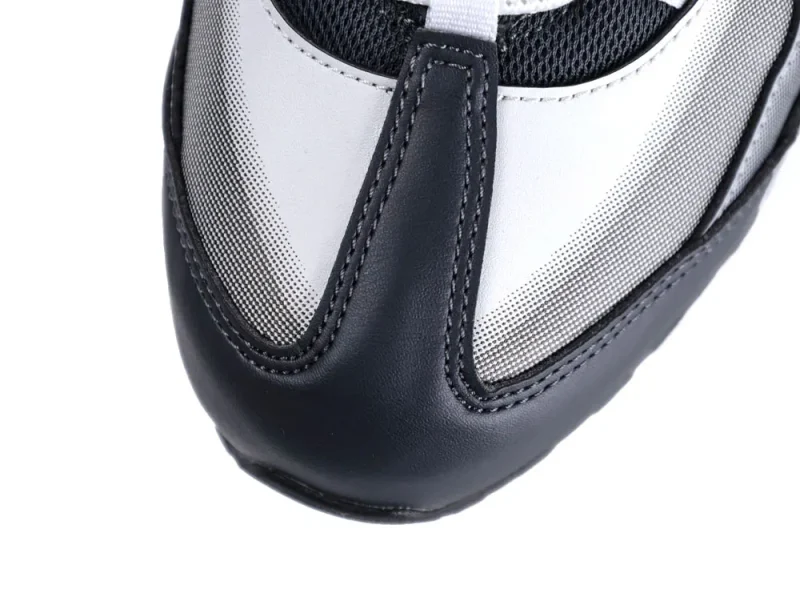 Close-up of a black and white leather sneaker toe with mesh accents.