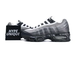 Gray and black sneakers with mesh material and visible air cushioning in the sole.