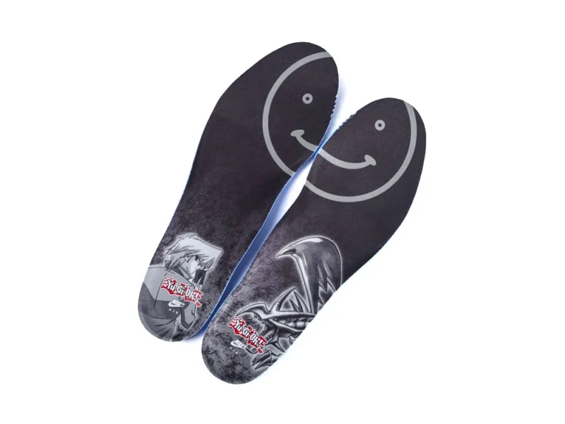 Dark insoles with printed graphics, featuring smiley face and character designs.
