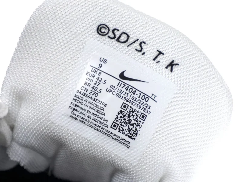 White fabric shoe tongue with printed black detail tag and a QR code.