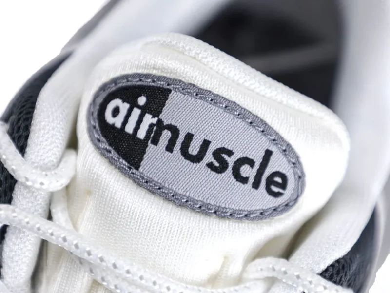 White fabric sneaker tongue with black and gray logo label, showing "airmuscle."