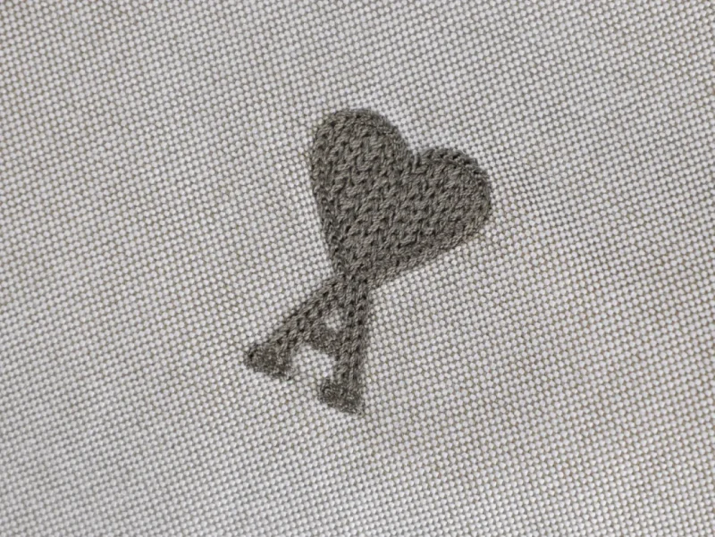 Embroidered heart on beige fabric background