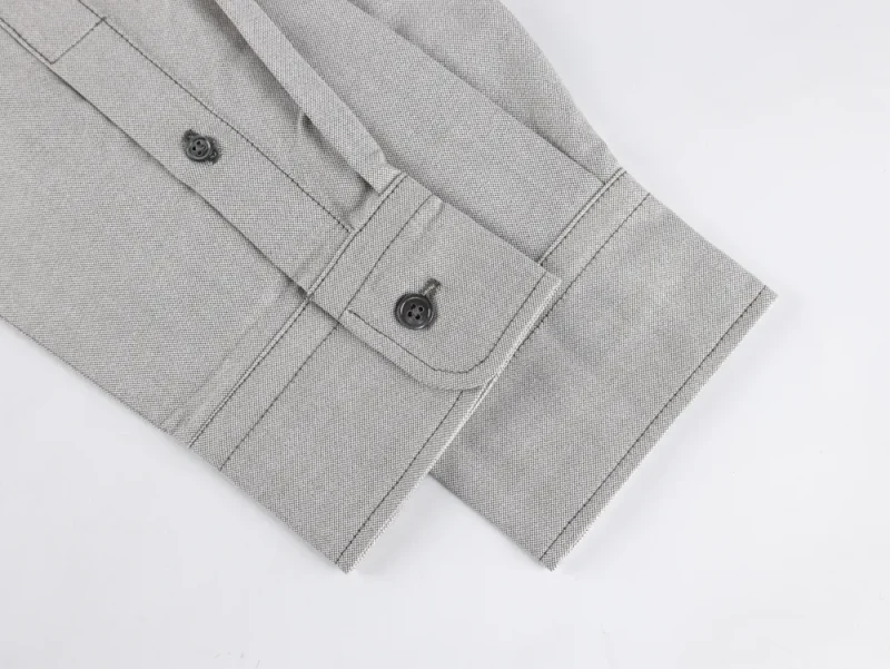 Cuff with buttons, showcasing textured material and precise stitching.