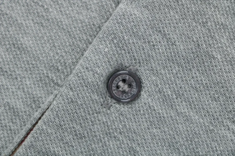 Black button detail, showing soft knitted texture.