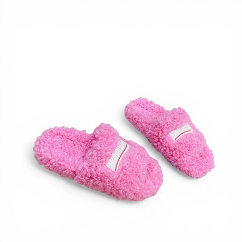 Pink fuzzy slippers with cushioned sole and soft upper material for comfort.