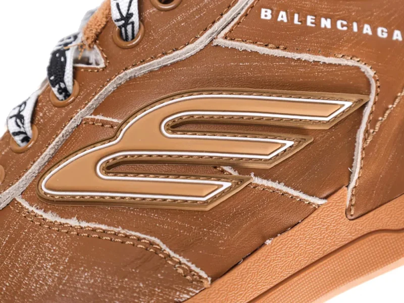 Brown leather sneaker with embossed logo detail and contrasting fabric laces.
