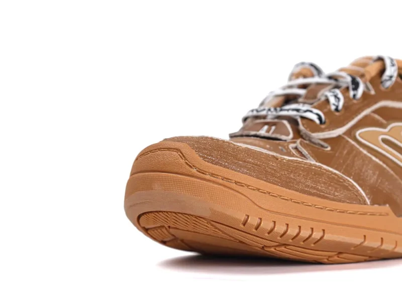 Brown sneaker with rubber sole and fabric upper, showcasing detailed stitching.