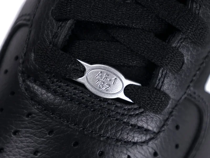 Black leather sneaker with black laces and silver "AF1 '82" emblem detail.