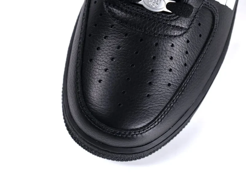 Black leather shoe with perforated design on the toe area.