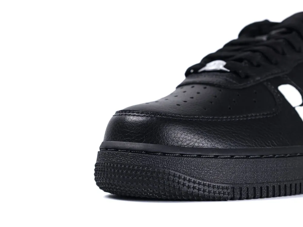 Black leather sneaker with textured rubber sole and perforated toe detailing.