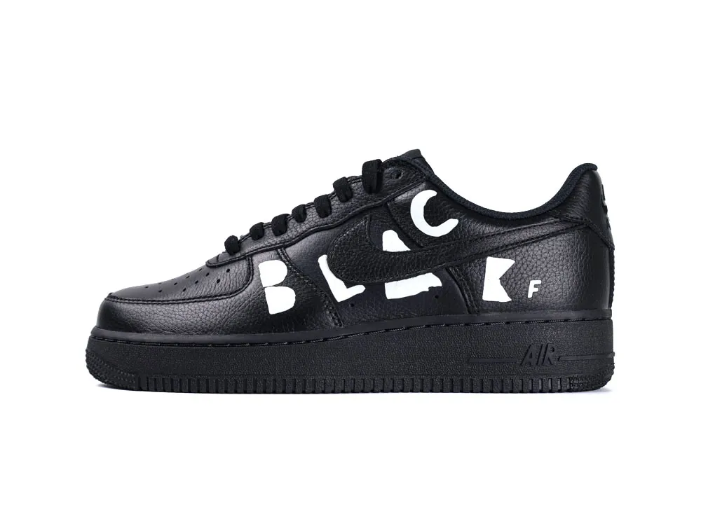 Black leather sneaker with perforated toe box and white letters on the side.