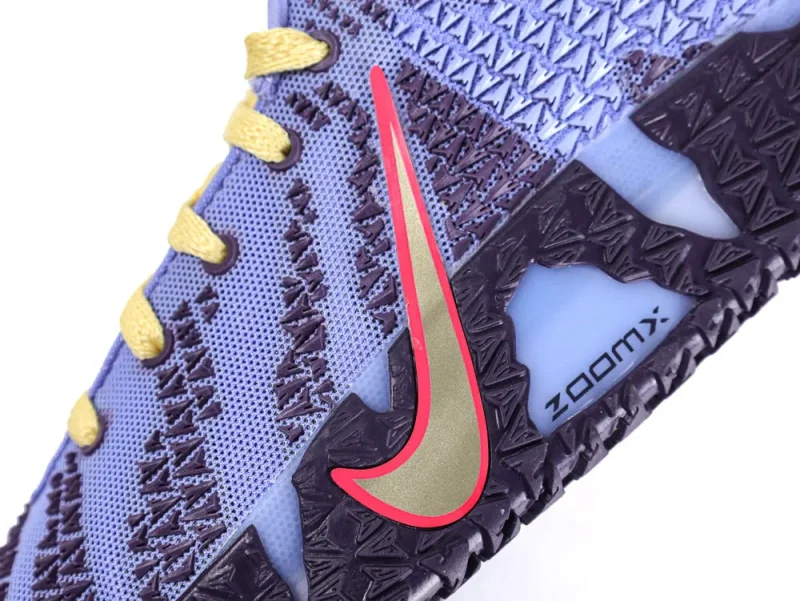 Blue mesh sneaker with yellow laces and textured dark sole, red logo detail.