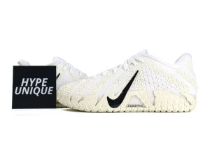 White woven sneakers with textured sole and black logo.
