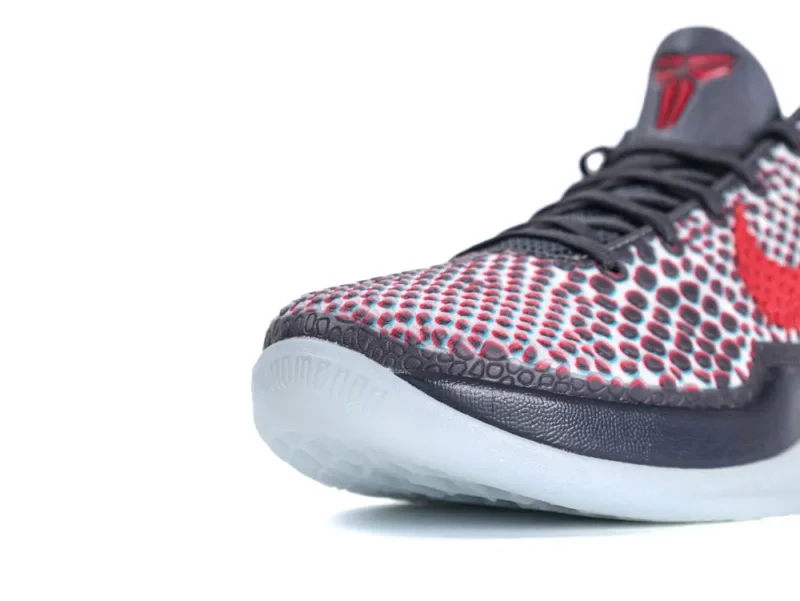 Close-up of a red and black sneaker with textured mesh and rubber sole.