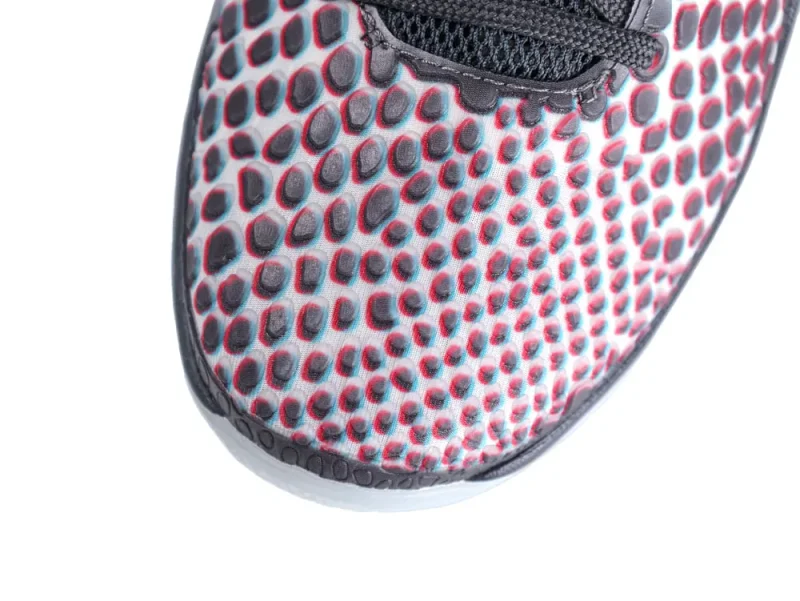 Close-up of patterned, multicolored mesh sneaker toe with black laces.