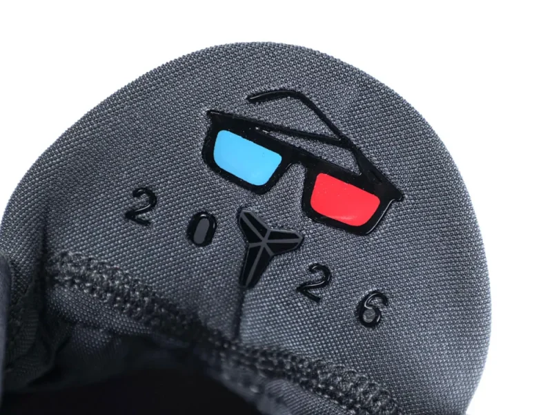 Gray fabric shoe tongue with colorful design, featuring blue and red accents.