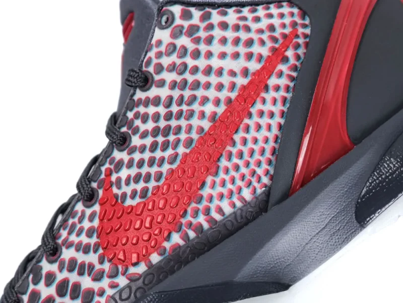 Close-up of red and gray patterned sneaker, featuring textured material and distinctive logo design.